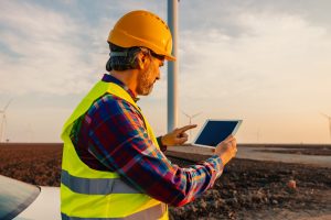 Engineer and tablet in wind power field working for renewable sustainable energy